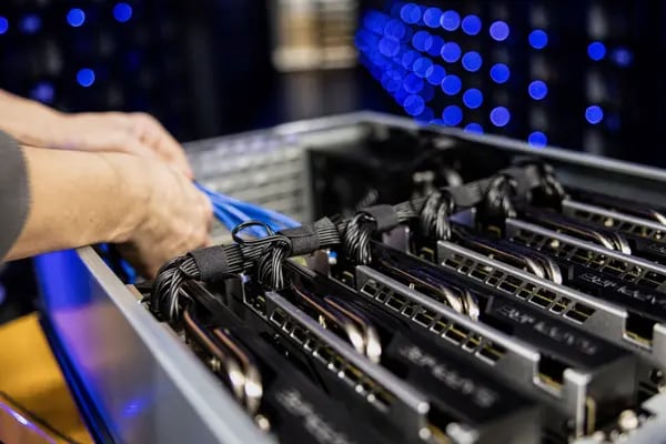 Un ingeniero arregla cables en una gaveta que almacena seis unidades procesadoras de gráficos de Sapphire Technology Ltd. AMD (GPU) usada para minería de Ethereum.