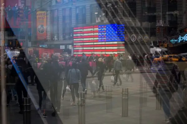 Peatones se reflejan en una ventana del Nasdaq MarketSite, en el barrio de Times Square de Nueva York, el lunes 8 de abril de 2019. Las acciones estadounidenses recortaron las pérdidas mientras los inversionistas esperaban señales de progreso en la guerra comercial con China antes de la última temporada de resultados corporativos.