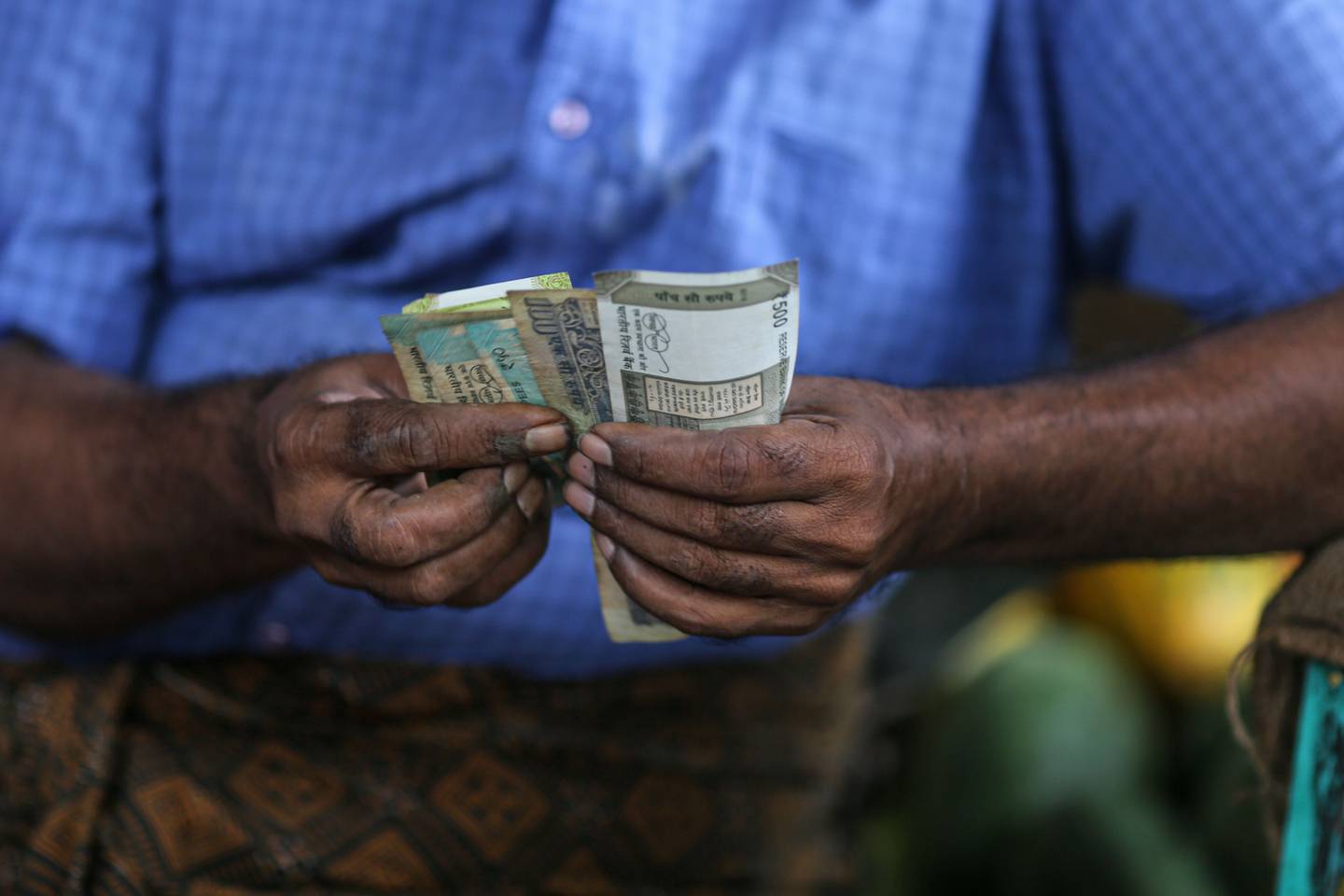 Un hombre cuenta billetes de rupias indias