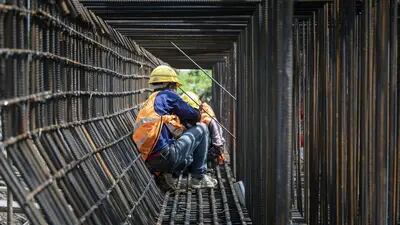 Obreros trabajan en la construcción de una autopista elevada en las afueras de Shanghai.