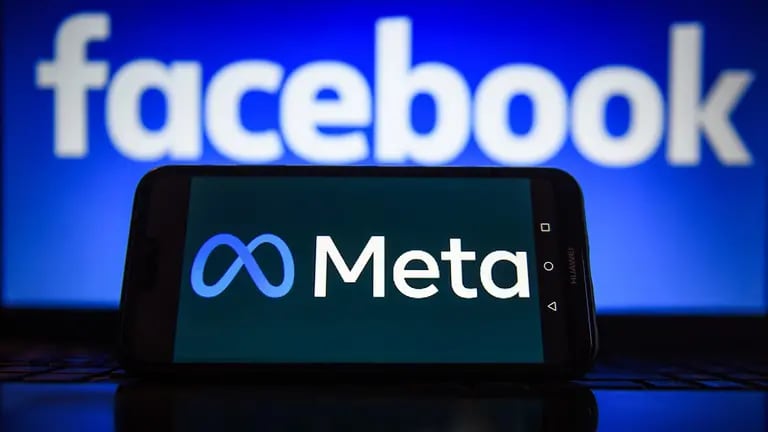 Logotipo de Meta en un smartphone con el logotipo de Facebook de fondo.dfd
