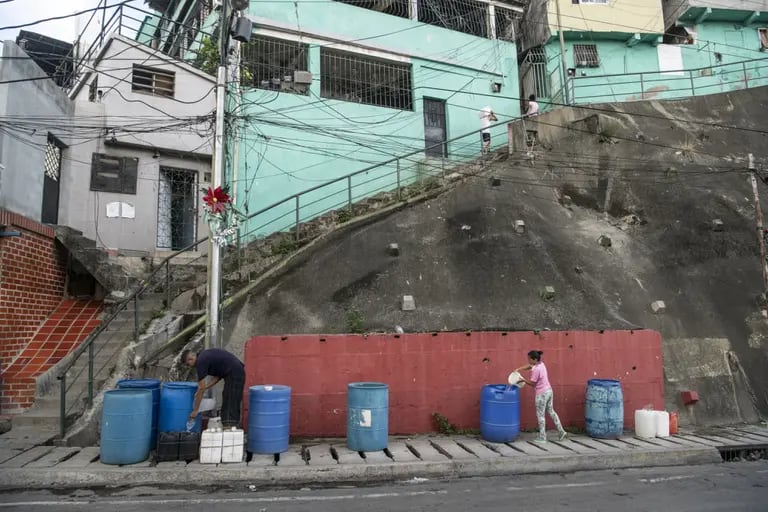 Personas llenan recipientes con agua en el barrio de Petare de Caracas, Venezuela, el lunes 15 de junio de 2020. Incluso cuando el Ministerio de Salud insta a los venezolanos a que se limpien las manos para detener la propagación del coronavirus, muchos en el país, incluida Caracas, todavía están sin una fuente de agua limpia. dfd