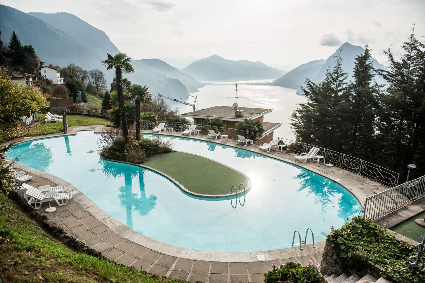 The swimming pool of a luxury residential property overlooks Lake Lugano from the hillside of Monte Bre, in Lugano, Switzerland.