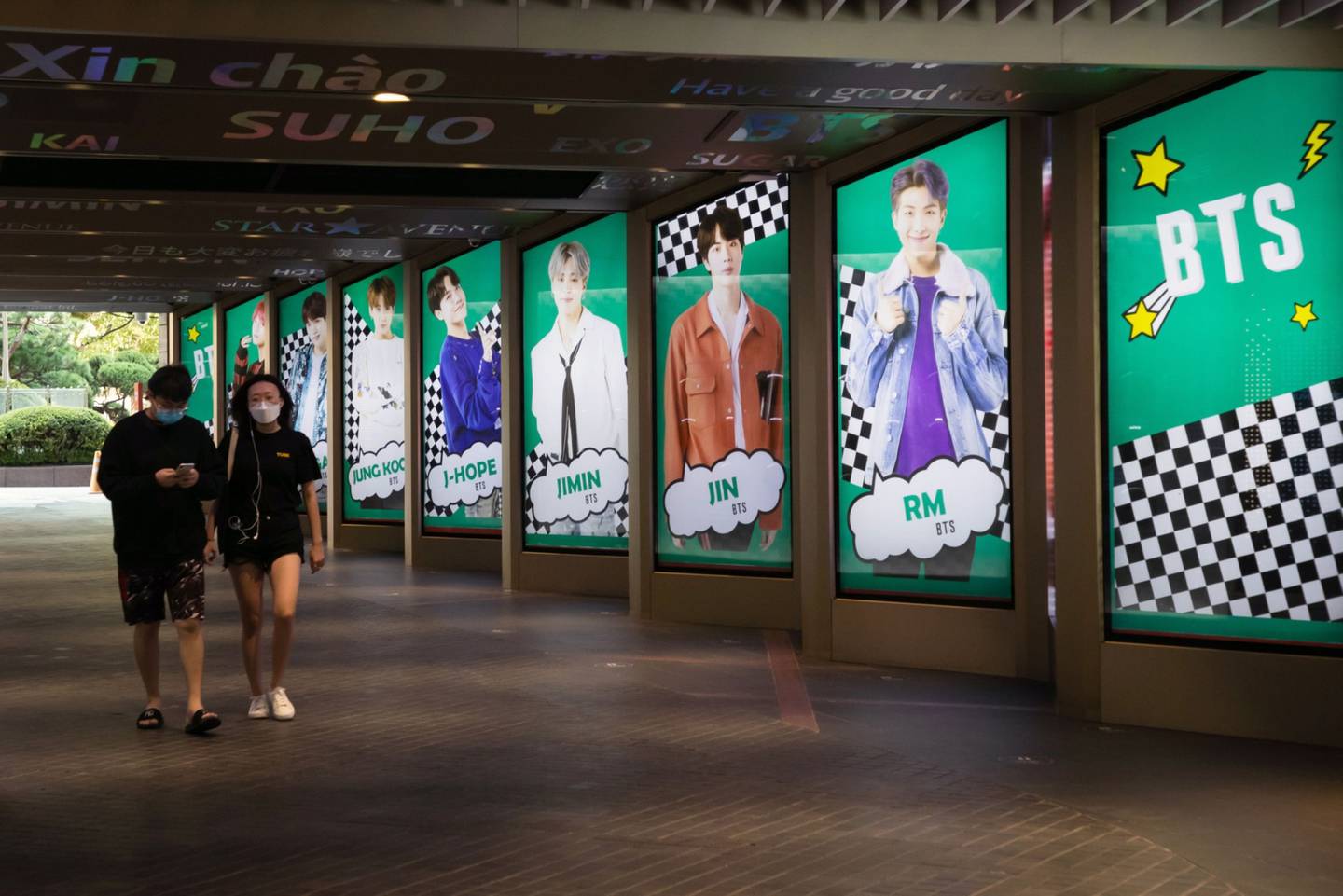 Pedestrians wearing protective masks walk past an advertisement for K-pop boy band BTS displayed in Seoul, South Korea, on Friday, Sept. 18. 2020. Big Hit Entertainment Co., the manager of K-pop boy band BTS, is looking to raise as much as 962.6 billion won ($812 million) in a South Korean initial public offering that is set to be the countrys largest in three years. Photographer: SeongJoon Cho/Bloombergdfd