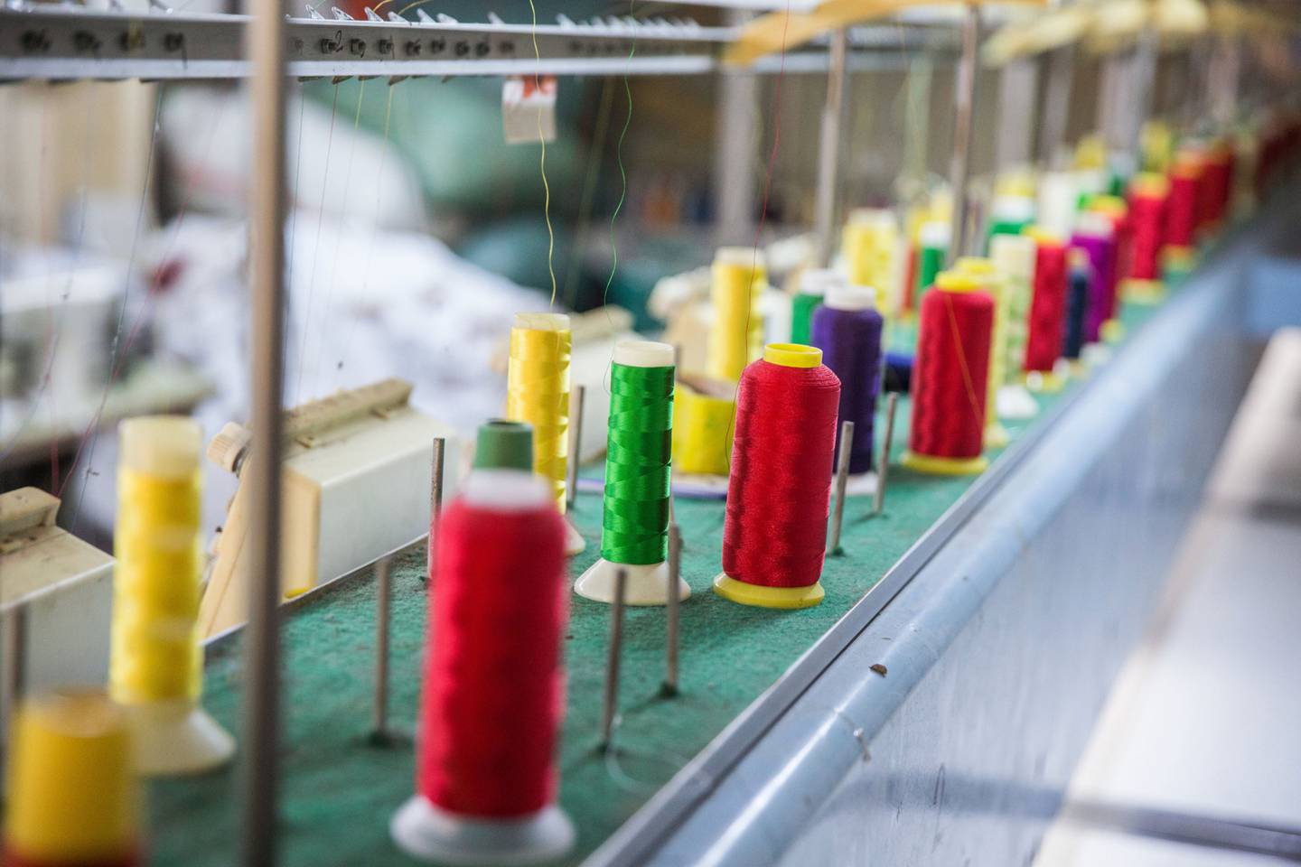 Carretes de hilo de algodón en una máquina de bordado textil en Myanmar. Fotógrafo: Taylor Weidman/Bloomberg