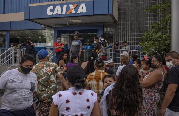 Brasileiros na fila de uma agência da Caixa para receber benefícios sociais em meio ao aumento das desigualdades e da pobreza no país com a pandemia