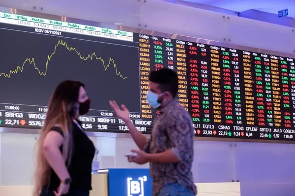Visitors in front of an electronic board displaying stock activity at the Brasil Bolsa Balcao (B3) stock exchange in Sao Paulo.