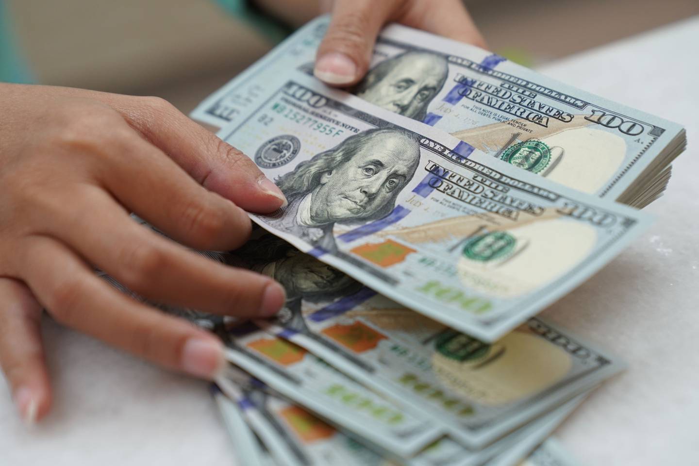 Un trabajador cuenta billetes de dólares estadounidenses en una oficina de cambio en Yakarta, Indonesia, el miércoles 2 de marzo de 2022.dfd