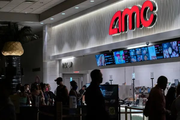 People wearing protective masks visit the concession stand at the AMC Lincoln Square 13 movie theater in New York, U.S., on Thursday, June 10, 2021.