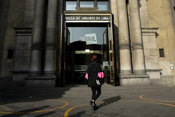 A pedestrian passes in front of the Lima Stock Exchange in Lima, Peru. Photographer: Miguel Yovera/Bloomberg