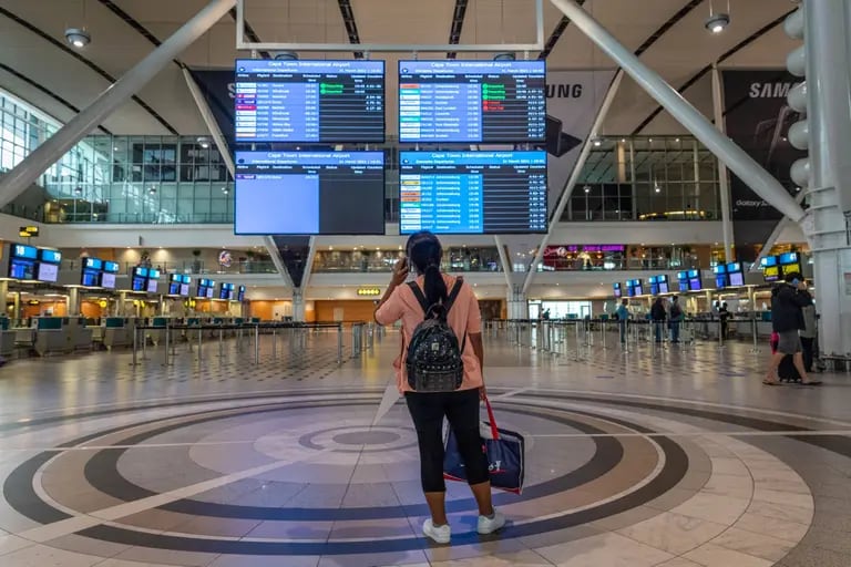 Una persona que viaja mira las pantallas de información de los vuelos en la terminal de salidas del Aeropuerto Internacional de Ciudad del Cabo.dfd