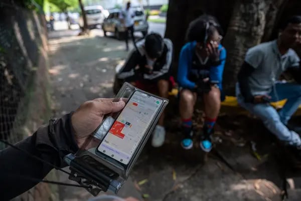 Un mensajero de reparto de comida en Rappi revisa un pedido en un smartphone en Cali, Colombia, el sábado 27 de mayo de 2023.