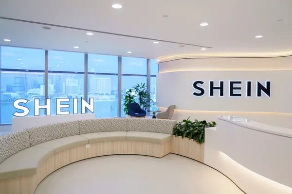 Imagem de um hall da sede da Shein, com tons claros e letreiros luminoso