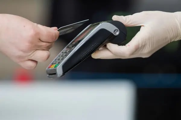 Un cliente utiliza una tarjeta bancaria para realizar un pago sin contacto en un puesto del mercado.