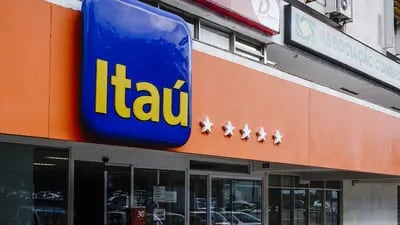 A pedestrian passes in front of a Itau Unibanco Holding SA bank branch in Brasilia