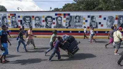 Venezolanos con equipaje caminan por el puente internacional Simón Bolívar hacia Cúcuta, Colombia, desde San Antonio del Táchira, Venezuela.