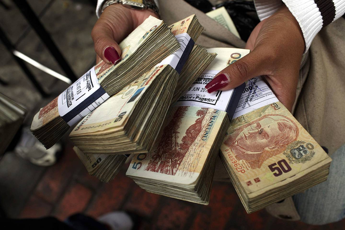 Peruvian bills are displayed as currency is traded on the street in Lima, Peru, on Tuesday, June 7, 2011.