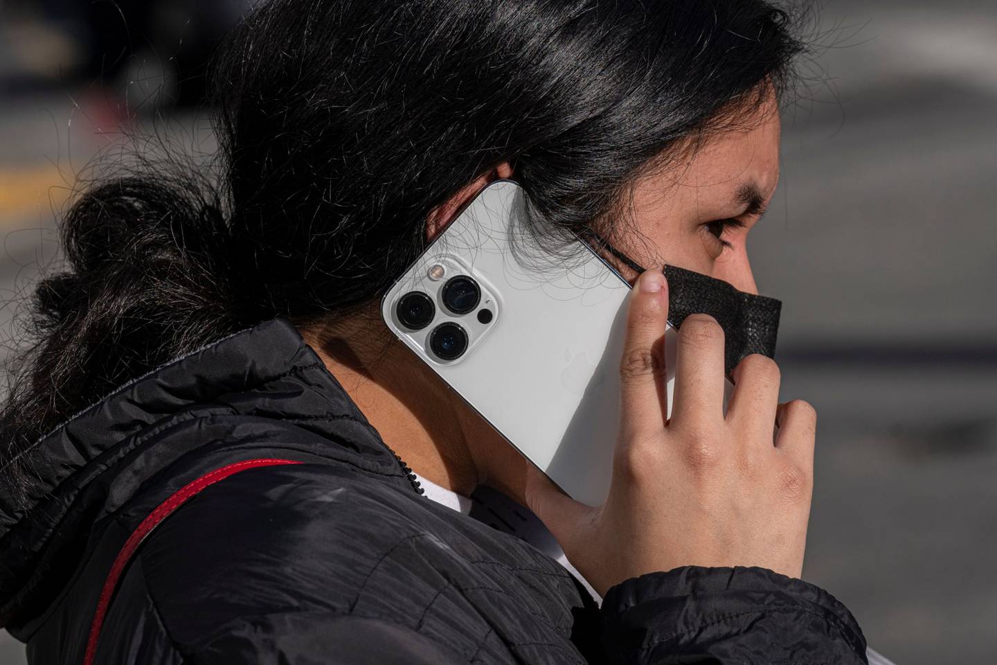 Un peatón usa un teléfono inteligente iPhone de Apple frente a una tienda en San Francisco, California, EE. UU., el lunes 24 de enero de 2022.