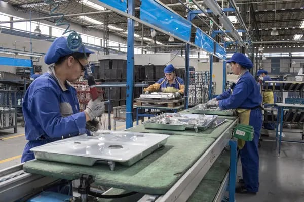 Empleados trabajan en piezas para una estufa en la línea de fabricación de electrodomésticos y muebles en la planta de producción de Challenger SAS en Bogotá, Colombia, el martes 20 de febrero de 2018.