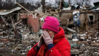 Irina Moprezova, 54, em frente a uma casa destruída por um bombardeio aéreo na cidade de Irpin, a noroeste de Kiev, em 13 de março de 2022