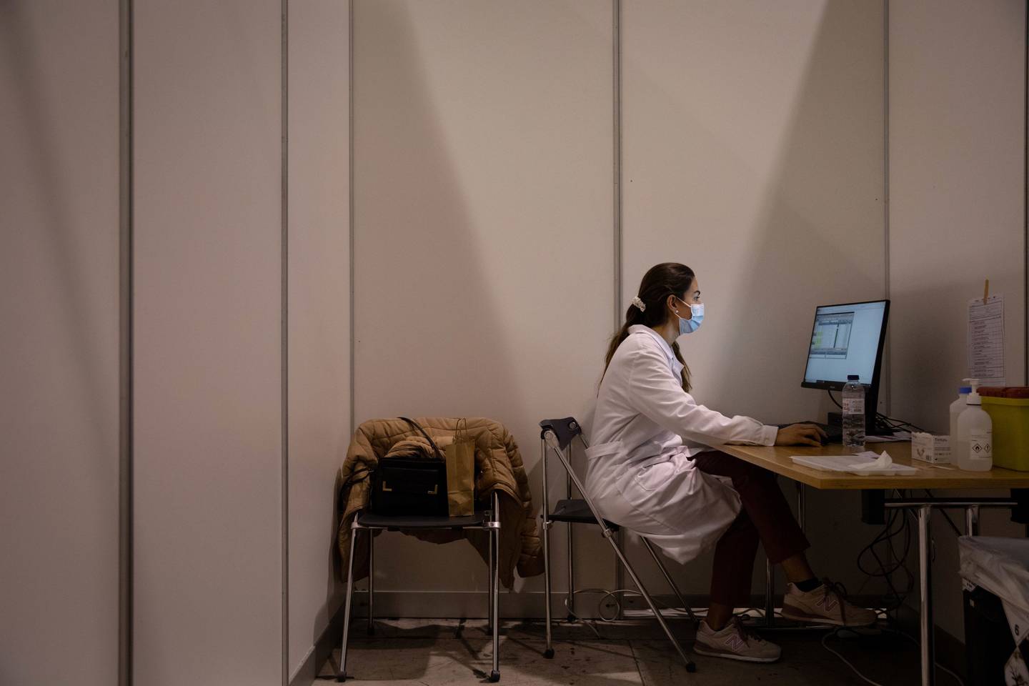 Una trabajadora sanitaria trabaja en un ordenador mientras espera a su próximo paciente en el mayor centro de vacunación masiva de Portugal en el Parque das Nacoes, Lisboa, Portugal, el domingo 19 de diciembre de 2021. Fotógrafo: Goncalo Fonseca/Bloomberg