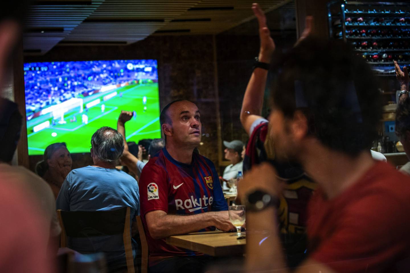 Aficionados al fútbol ven el partido de Liga entre el FC Barcelona y la Real Sociedad en Barcelona.