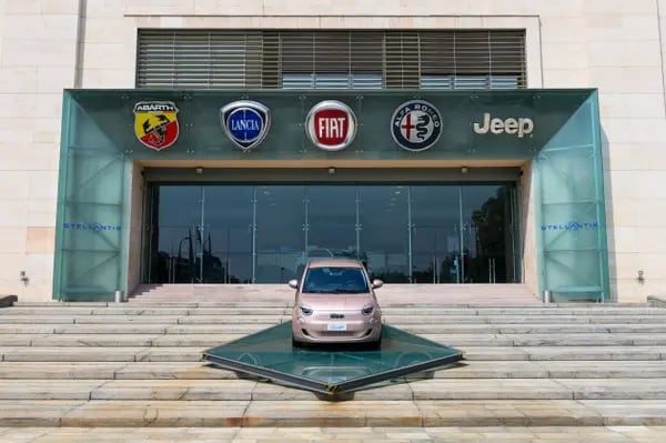 Un automóvil Fiat 500 en la entrada de la planta de Mirafiori, que sirvió como sede de Fiat Chrysler Automobiles NV, es parte de Stellantis NV, en  Italia, donde lleva varias semanas de pugna con el gobieno de Meloni por la disminución de plantilla y el traslado de porducción de VE a otros países de la UE. Fotógrafo: Giuliano Berti/Bloomberg