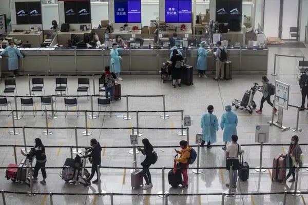 Viajeros dirigiéndose a la cuarentena en la sala de llegadas del Aeropuerto Internacional de Hong Kong en Hong Kong, China, el viernes 1 de abril de 2022. Un fotógrafo: Paul Yeung/Bloomberg