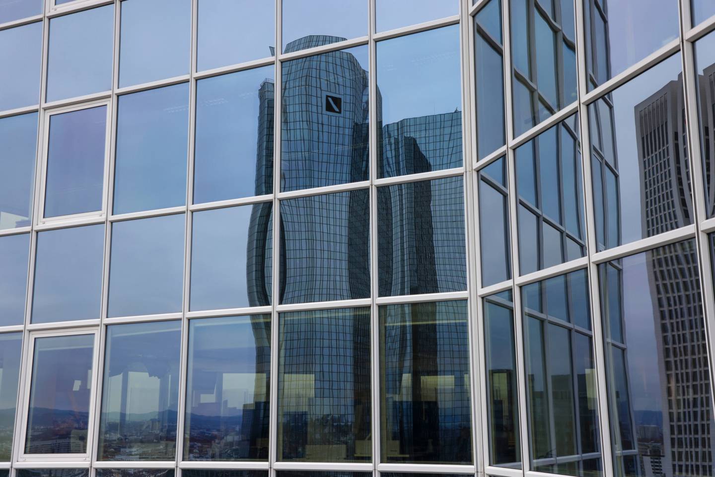 La sede del Deutsche Bank reflejada en las ventanas de un edificio de oficinas. Fotógrafo: Alex Kraus/Bloomberg