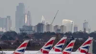La librea de British Airways en las aletas de la cola de los aviones de pasajeros en el aeropuerto londinense de Heathrow, a la vista de los rascacielos de la City de Londres, Reino Unido, el miércoles 23 de febrero de 2022.