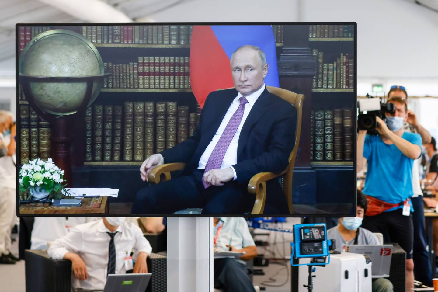 Periodistas observan a través de cámaras una conferencia entre Vladimir Putin y Joe Biden.