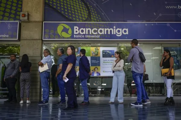 Customers wait outside of the Bancamiga Banco Universal headquarters in Caracas, Venezuela, on Wednesday, April 10, 2024. Dozens of Venezuelans lined up Wednesday to withdrawn funds from Bancamiga branches following allegations of ties to the arrested former ministers Tareck El Aissami and Simon Zerpa, as well as financier Samark Lopez, more than a year after an investigation into billions of lost Petroleos de Venezuela SA revenue that's led to a purge of the ruling elite's inner circle. Photographer: Matias Delacroix/Bloomberg