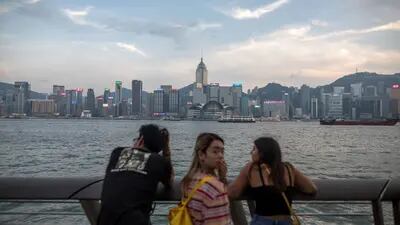 La gente mira a través del puerto de Victoria hacia el horizonte de la isla de Hong Kong desde el distrito de Tsim Sha Tsui de Hong Kong, China, el martes 20 de agosto de 2019. Fotógrafo: Paul Yeung/Bloomberg