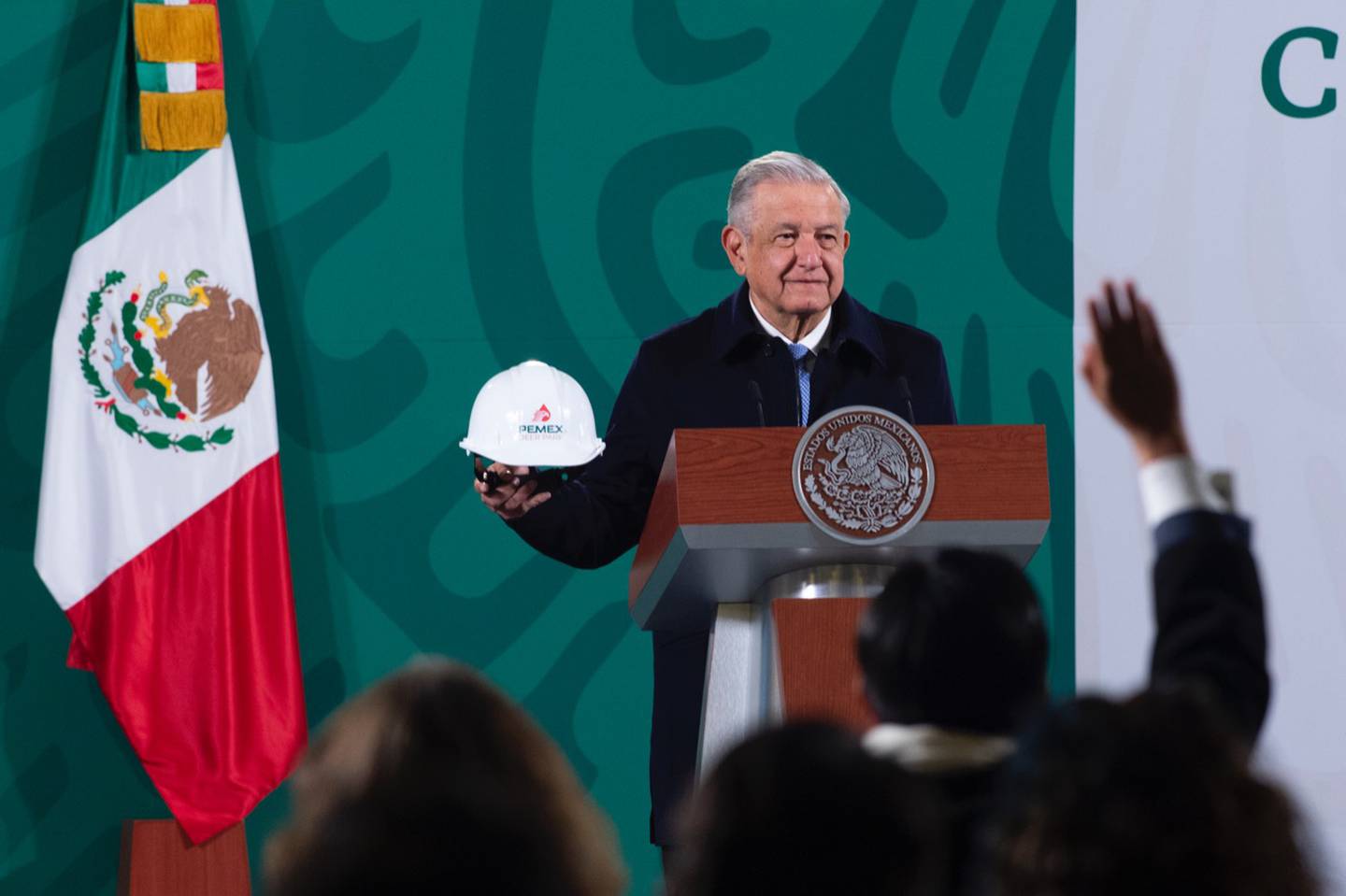 El presidente de México, Andrés Manuel López Obrador (AMLO) sostiene un casco de Pemex de la refinería Deer Park en Texas, Estados Unidos, durante una conferencia de prensa.