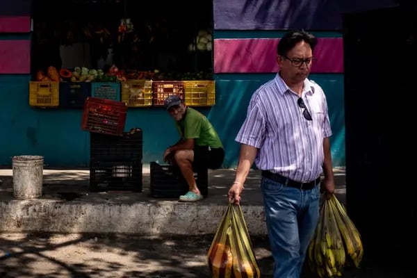 Un vendedor vende productos agrícolas en un mercado en Barquisimeto, Venezuela.