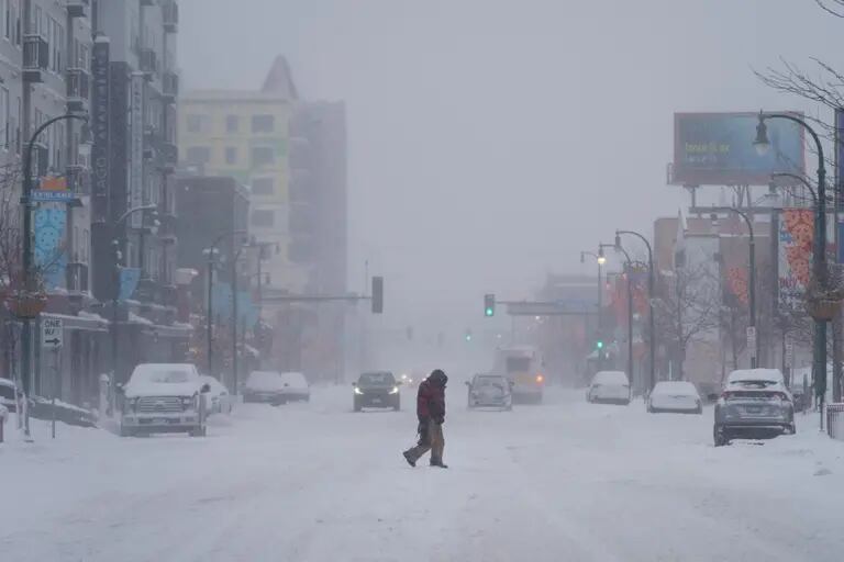 Un peatón cruza una carretera cubierta de nieve durante una tormenta en Minneapolis, Minnesota, EE.UU., el jueves 23 de febrero de 2023. Una tormenta invernal se extiende por el norte de EE.UU. esta semana, desatando frío y nieve desde California hasta Maine, mientras en el sureste se registra un calor récord. Fotógrafo: Tim Evans/Bloombergdfd
