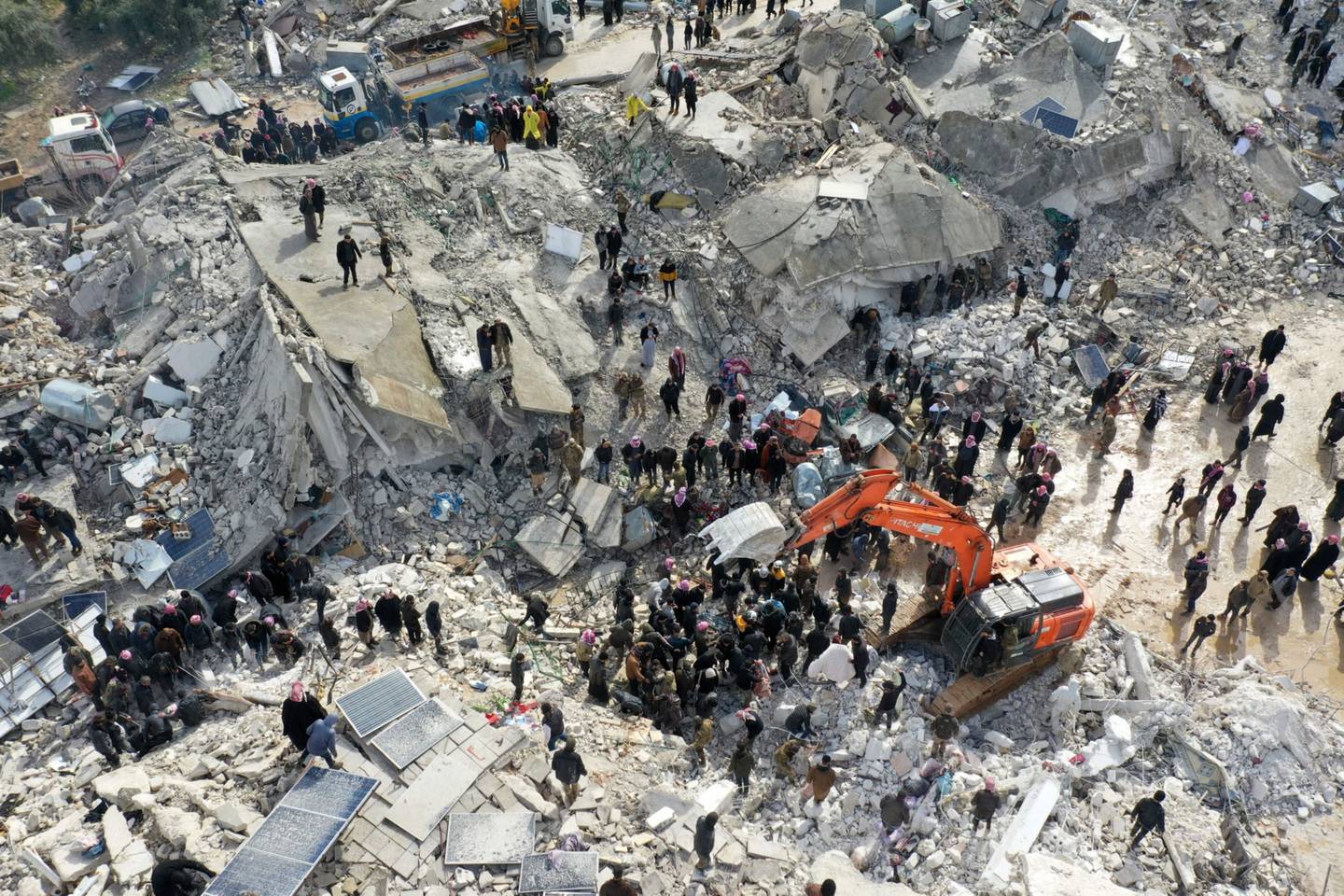 Esta vista aérea muestra a los residentes, ayudados por equipos pesados, buscando víctimas y supervivientes entre los escombros de los edificios derrumbados tras un terremoto en el pueblo de Besnia, cerca del twon de Harim, en la provincia siria de Idlib, controlada por los rebeldes, en la frontera con Turquía, el 6 de febrero de 2022. Fotógrafo: Omar Haj Kadour/AFP/Getty Images