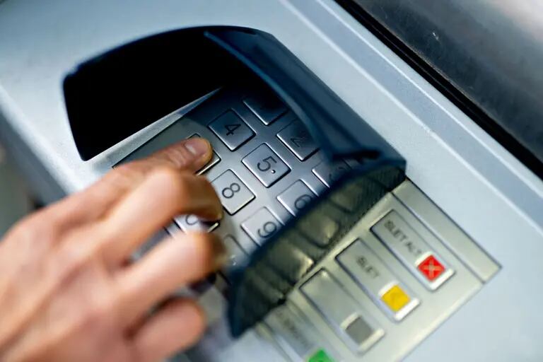Un cliente bancario usa el teclado de un cajero automático (ATM).dfd