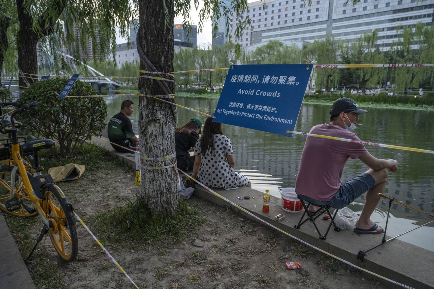 Un letrero y una cinta de barrera colocados para evitar que grandes grupos se reúnan en un parque al aire libre en Beijing, el 28 de mayo.