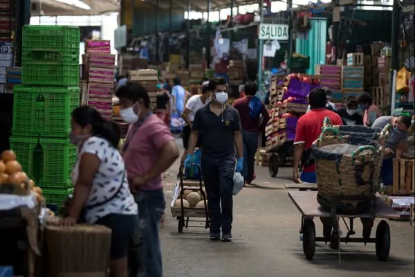 Las personas que usan máscaras protectoras compran en un mercado en el barrio La Victoria de Lima, Perú, el viernes 17 de abril de 2020