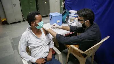Um profissional de saúde administra vacina contra a Covid-19 em Nova Déli
