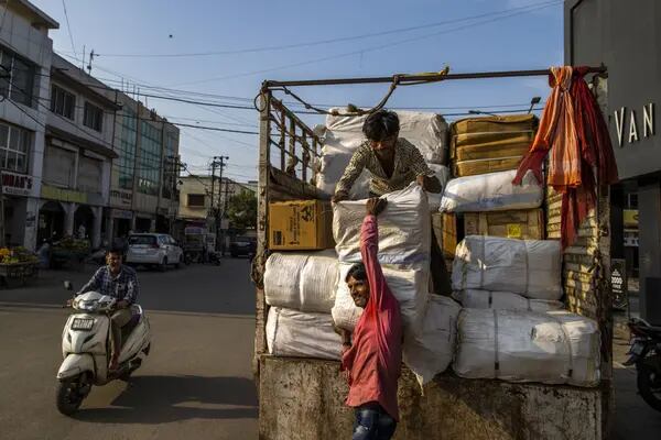 Trabajadores descargan mercancías de un camión en la zona del mercado principal de Gandhidham, India, el jueves 8 de septiembre de 2022.