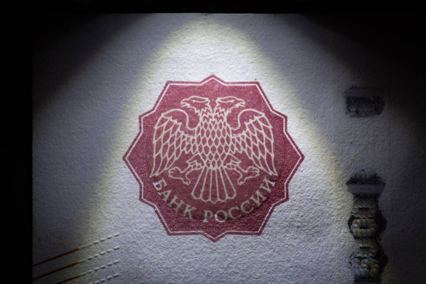 The Russian imperial double-headed eagle coat of arms, the emblem of Russia's central bank, sits on a ruble banknote in this arranged photograph in Moscow,