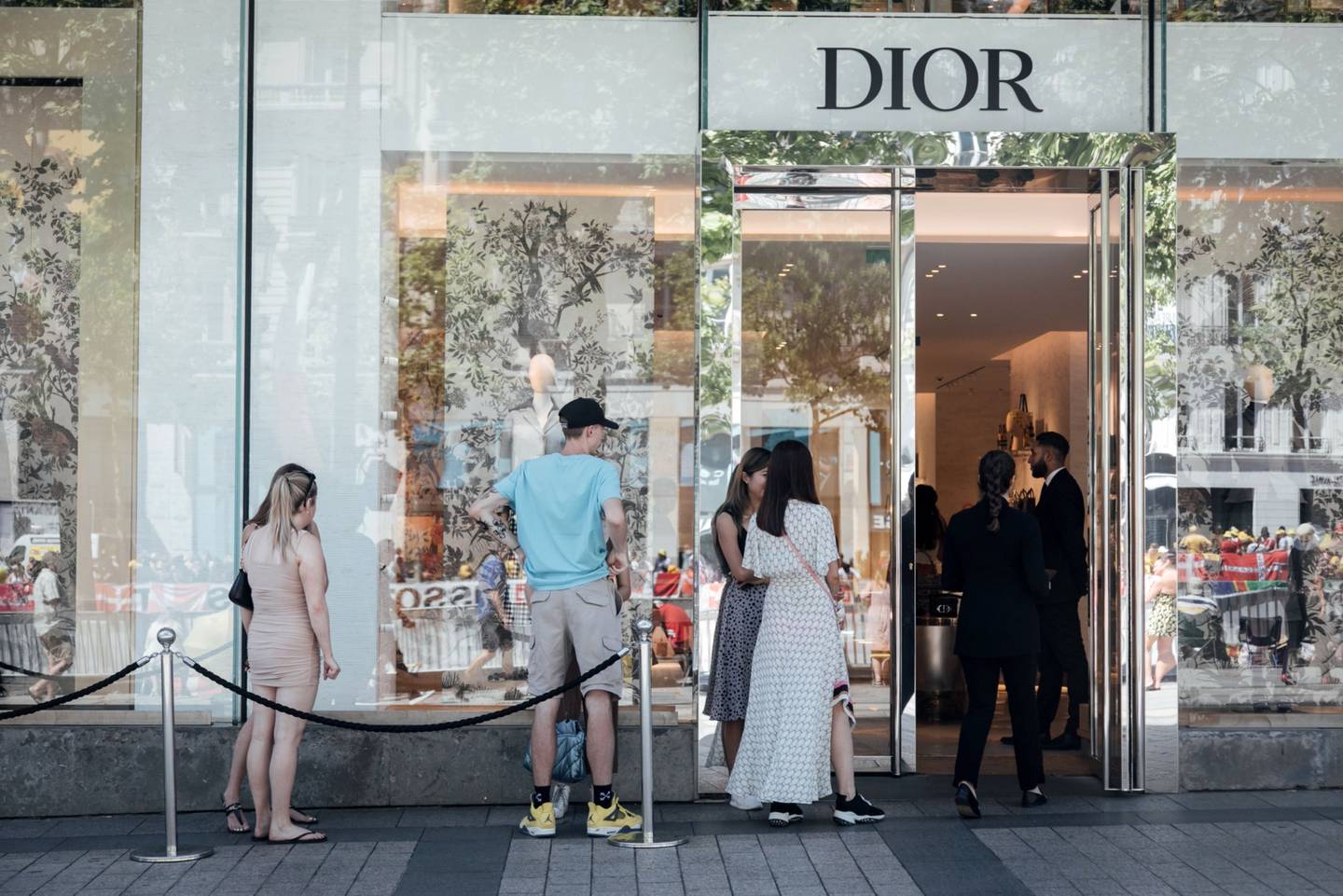 Los clientes hacen fila para entrar en una tienda de lujo Christian Dior SE en los Campos Elíseos en París, Francia, el domingo 24 de julio de 2022.