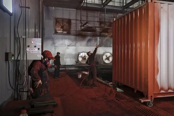 Un trabajador rocía pintura sobre un contenedor marítimo en el taller de pintura de la fábrica Singamas Container Holdings Ltd. en Qidong, China, el jueves 22 de junio de 2017