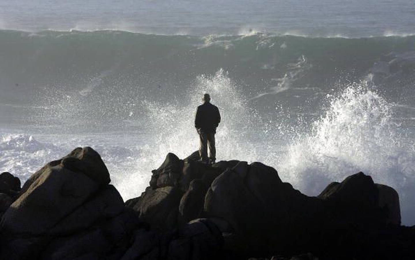 Un hombre observa cómo las grandes olas se estrellan contra las rocas el 7 de febrero de 2006 en Pacific Grove, California.