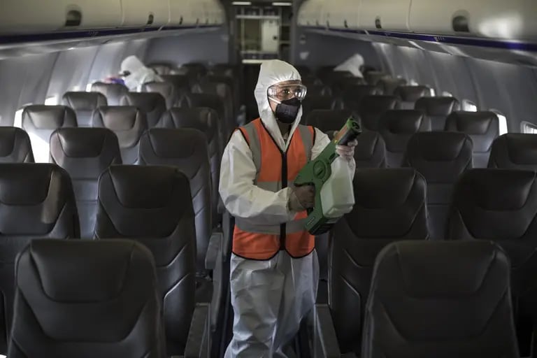 Los trabajadores desinfectan un avión antes de que se reanuden los vuelos en el Aeropuerto Internacional El Dorado (BOG) en Bogotá, Colombia, el lunes 31 de agosto de 2020.dfd