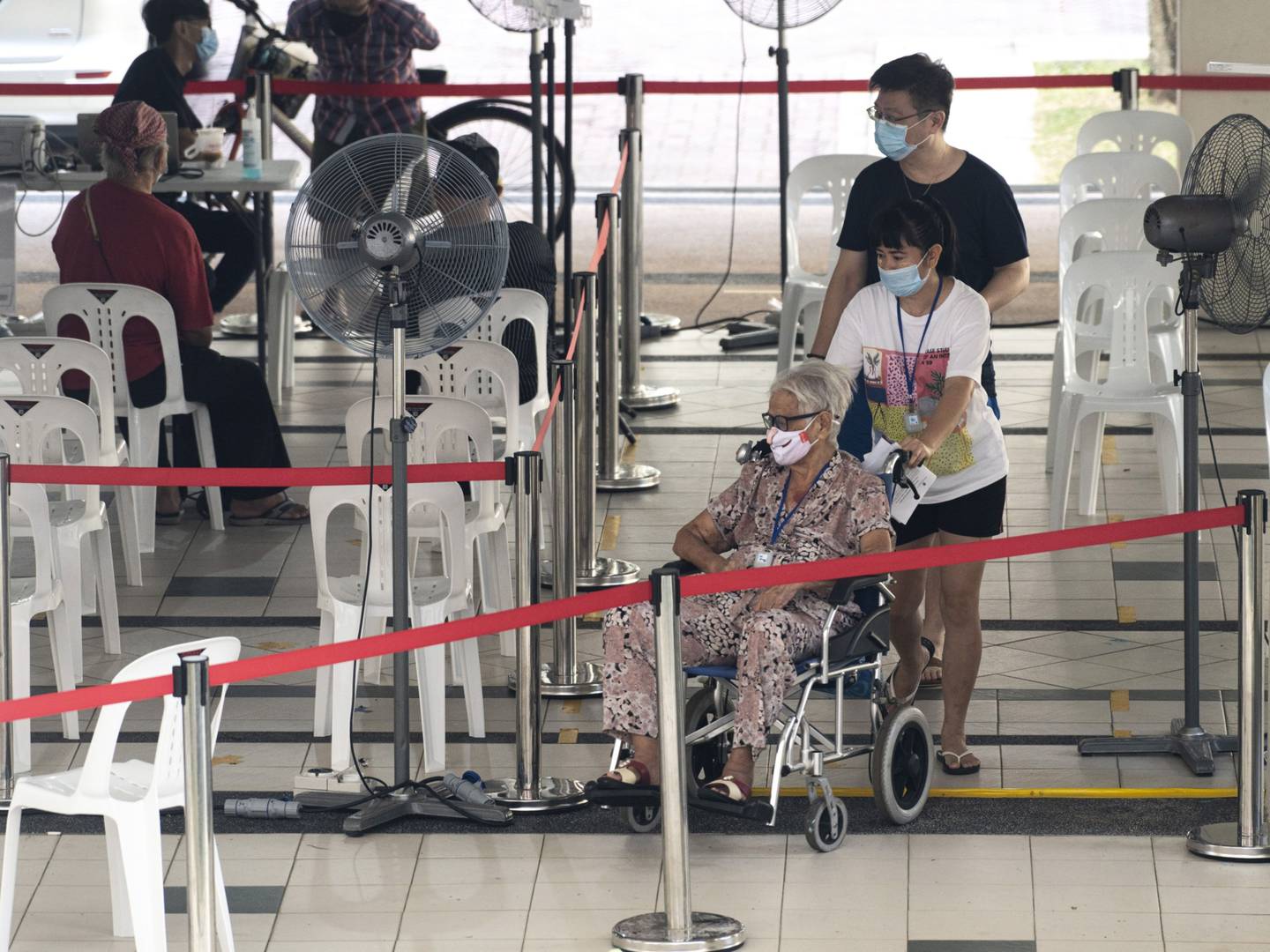 Una anciana espera para recibir la vacuna contra el Covid-19 en un centro de vacunación en Singapur, el sábado 25 de septiembre de 2021.