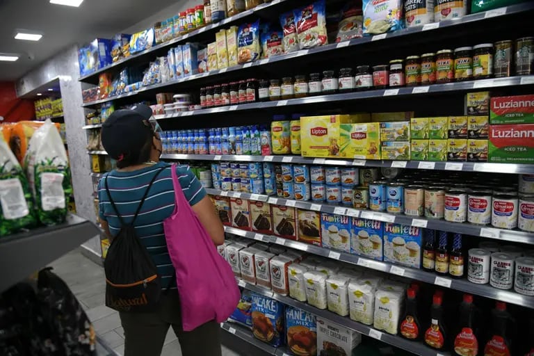 Una mujer revisa productos nacionales e importados en el estante de una tienda en Caracas, Venezuela, el lunes 2 de agosto de 2021.dfd