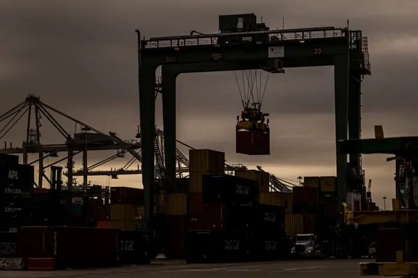 Una grúa levanta un contenedor de transporte en el puerto de Oakland, California.